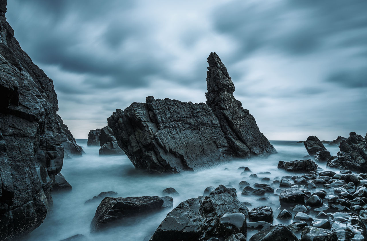 COLORBOND® steel in the colour Monument®.  Rocky outcrop jutting out of the misty sea.