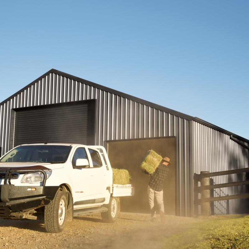 COLORBOND® steel. Tree Change. Farmer unloading hay bale infront of a Farm Barn. Flatlay Inspiration.