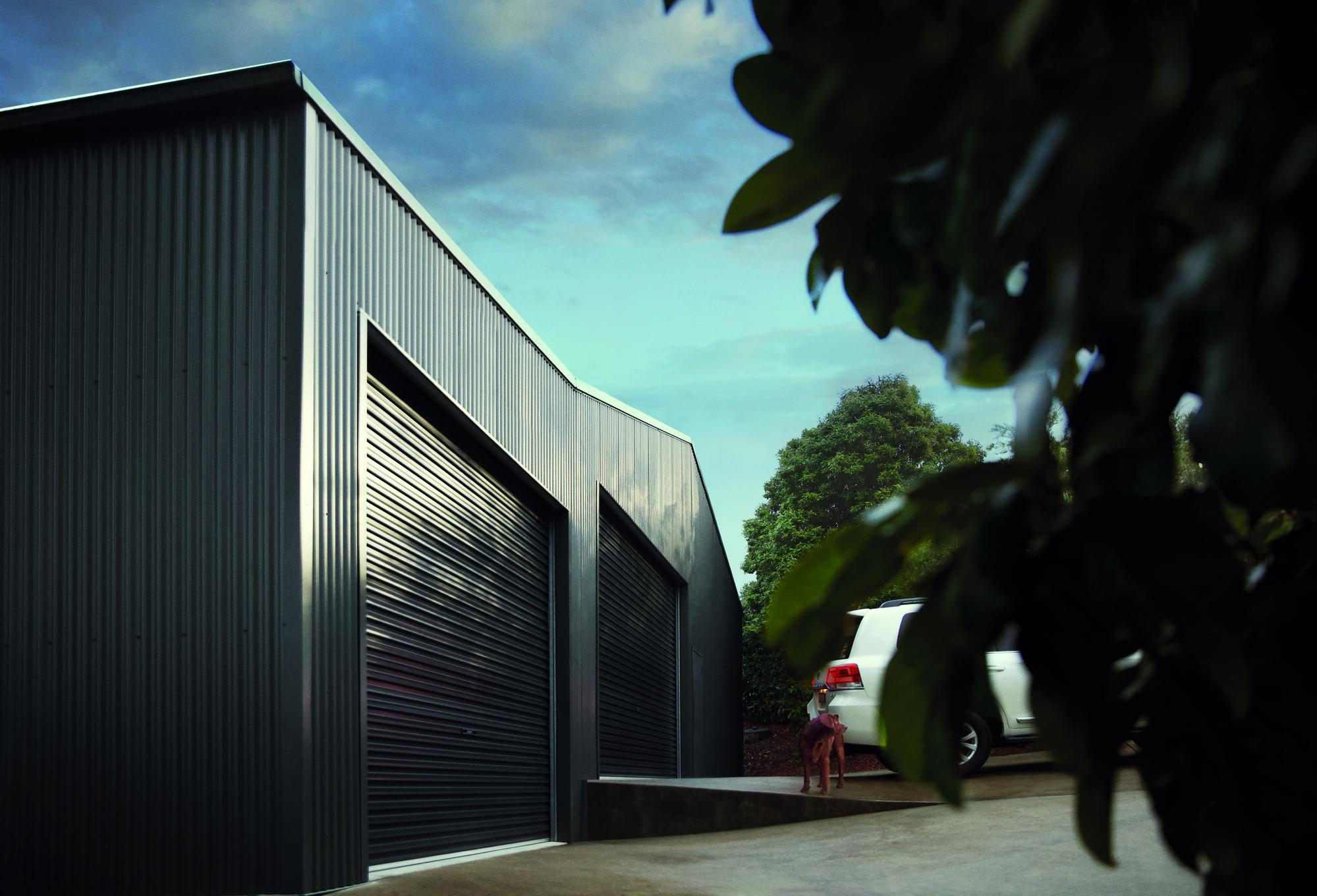 Car enthusiast Shed. Roofing and Walling made from COLORBOND® steel in colours Woodland Grey®.  Roller doors made from COLORBOND® steel in colour Monument®